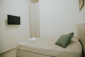 a bedroom with a bed with a flat screen tv at Nonno Turiddru Guest House in Marsala