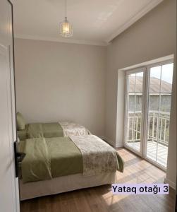 a bedroom with a bed and a large window at Sheki Center Home in Sheki