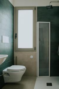 a bathroom with a toilet and a window and a sink at Nonno Turiddru Guest House in Marsala +6 photos