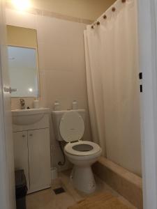 a bathroom with a toilet and a sink and a mirror at La hora azul departamentos in Playas Doradas +82 photos