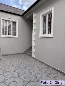 a white house with two windows and a patio at Sheki Center Home in Sheki