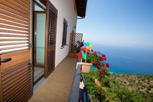 a balcony with a door and flowers in a pot at B&B Incantevole Vicolo in Piraino