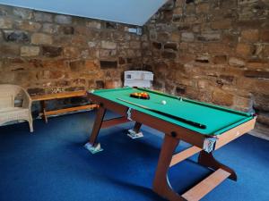 a ping pong table in a room with a stone wall at Broomfields Glamping Pods in Whitby