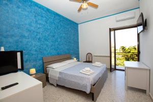 a bedroom with a bed and a tv and a window at B&B Incantevole Vicolo in Piraino