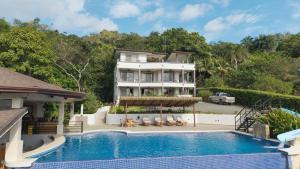 an exterior view of a house with a swimming pool at Hotel Las Lomas in Nandayure
