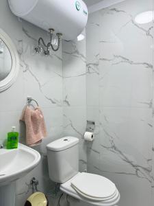 a white bathroom with a toilet and a sink at JEA House in Pogradec +17 photos
