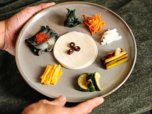 a person holding a plate full of different types of vegetables at Mövenpick Hotel Auckland in Auckland