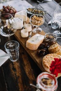 a wooden table topped with cheese and other foods at B&B D'Issy in Issy-lʼÉvêque +9 photos