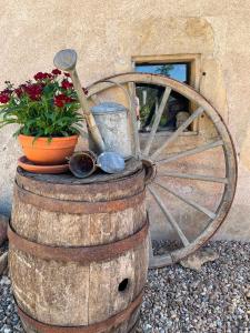 a wooden wagon wheel sitting on top of a barrel with flowers at B&B D'Issy in Issy-lʼÉvêque
