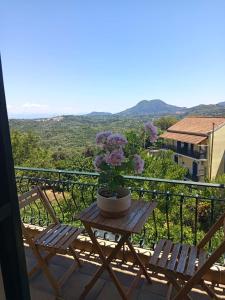 a table with a vase of flowers on a balcony at Agnes Rooms in Pelekas