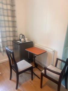 a table and two chairs in a room with a table at Peace Guest House in Hoo