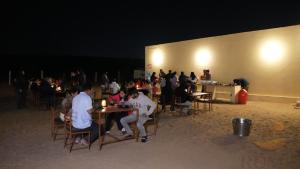 a group of people sitting at tables at night at Rumis Desert Camp in Jaisalmer