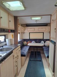 an rv kitchen with a table and a sink at Private caravan with mountain and sea view in Guájar-Faragüit