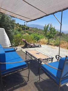 a group of chairs and a table with an umbrella at Private caravan with mountain and sea view in Guájar-Faragüit