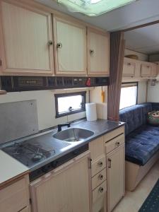 an rv kitchen with a sink and a couch at Private caravan with mountain and sea view in Guájar-Faragüit
