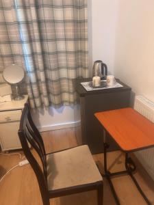 a table and a chair with a tea kettle on it at Peace Guest House in Hoo