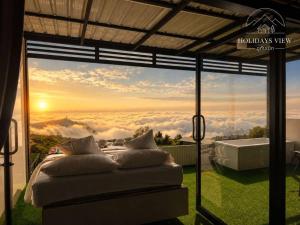 a bedroom with a large window with a view at Holiday view ภูทับเบิก in Ban Maeo Thap Boek