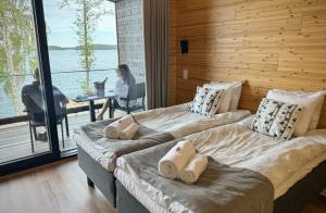 two beds in a room with a woman sitting at a table at Radalla Resort in Kausala +45 photos