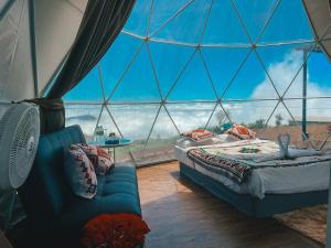 a room with a tent with a bed and a couch at Holiday view ภูทับเบิก in Ban Maeo Thap Boek