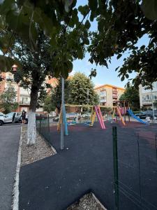 an empty playground with a tree and swings at Home Studio Arad in Arad