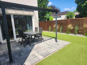 a patio with a table and chairs on a lawn at Borndal-Zeit in Altenberge +4 photos