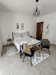 a bedroom with a bed and two chairs at Masseria Santa Laria in Borgagne
