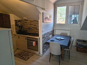 a small kitchen with a table and a sink and a stove at Attico Sole e Mare in Ventimiglia