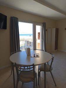a dining room with a table and chairs and a window at La hora azul departamentos in Playas Doradas