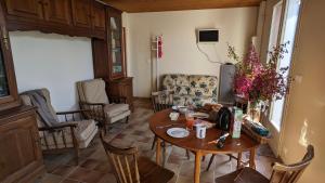 a living room with a wooden table and chairs at La maison de papy près de la plage in Barbâtre