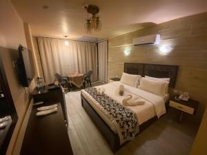 a hotel room with a large bed and a table at AL NAHAR AL KHALEd in Aqaba