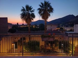 a view of palm trees from a balcony at sunset at FILANGERI 116 in Santa Flavia