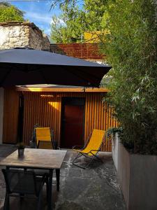 a patio with a table and chairs and an umbrella at Ca' Lumaga -Charming Holiday Studio in Chiavenna