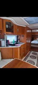 a kitchen with wooden cabinets and a bed on a boat at Tabber Trolltunga caravan in Odda