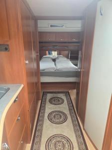 a small room with a bed and a rug at Tabber Trolltunga caravan in Odda
