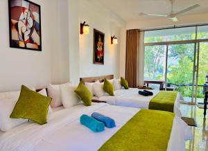 a bedroom with two beds with green and white pillows at Ella Pine Crest in Ella