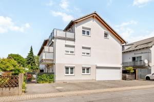 a white house with a roof at Retreat Living - Business-Apartment mit 3 Schlafzimmern, 2 Bädern & Sauna - kostenloser Parkplatz in Bensheim