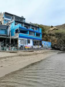 a blue building on the beach next to the ocean at Shadday taganga in Santa Marta