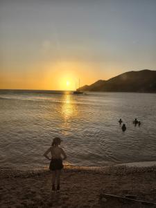 a woman standing on the beach watching the sunset at Shadday taganga in Santa Marta
