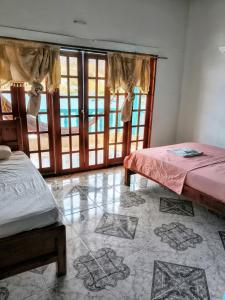 a room with two beds in a room with windows at Shadday taganga in Santa Marta