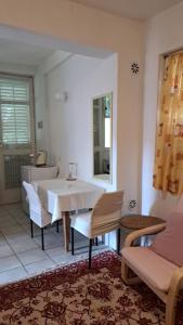 a dining room with a white table and chairs at Apartmani Primorski hrast in Bar +15 photos