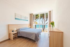 a bedroom with a bed and a window with the ocean at Appartamenti BluMare in Diano Marina