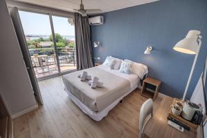 a bedroom with a bed and a large window at Hotel Boutique La Brisa in Vilanova i la Geltrú
