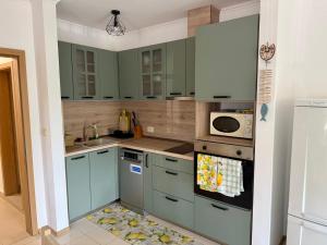 a kitchen with green cabinets and a sink at The Lemon Villa in Rogachevo