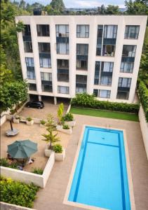 a large building with a swimming pool in front of it at Bellora Urban Homes in Ongata Rongai 