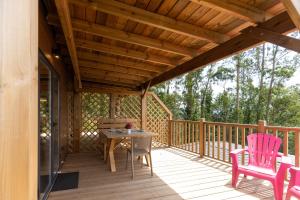 a wooden deck with a table and two chairs at Camping As Cancelas in Santiago de Compostela