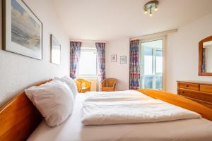 a bedroom with a large bed and a window at Gemütliche Ferienwohnung mit Wintergarten & Meerblick am Südstrand Wohnung 123 in Wilhelmshaven