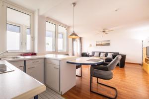 a kitchen and living room with a table and chairs at Gemütliche Ferienwohnung mit Wintergarten & Meerblick am Südstrand Wohnung 123 in Wilhelmshaven