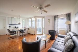 a living room with a couch and a table at Gemütliche Ferienwohnung mit Wintergarten & Meerblick am Südstrand Wohnung 123 in Wilhelmshaven +5 photos