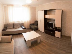 a living room with a couch and a tv at 2k Apartment near Ashan in Tyumen