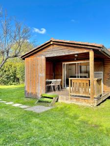 a wooden cabin with a deck with a table at Domaine des Epinettes in Saint-Romain-de-Jalionas